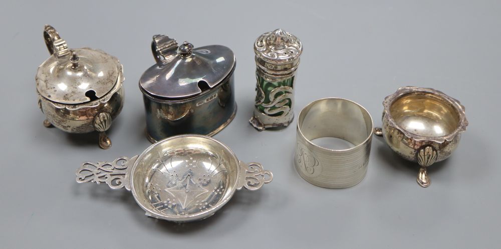 A silver tea strainer, a silver serviette ring and five various silver condiments, 8oz (excluding liners)